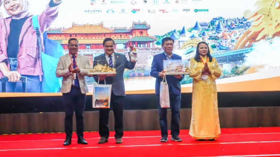 Presenting souvenirs to VIP delegates during the Central Vietnam tourism promotion program in Malaysia. Photo: Department of Tourism